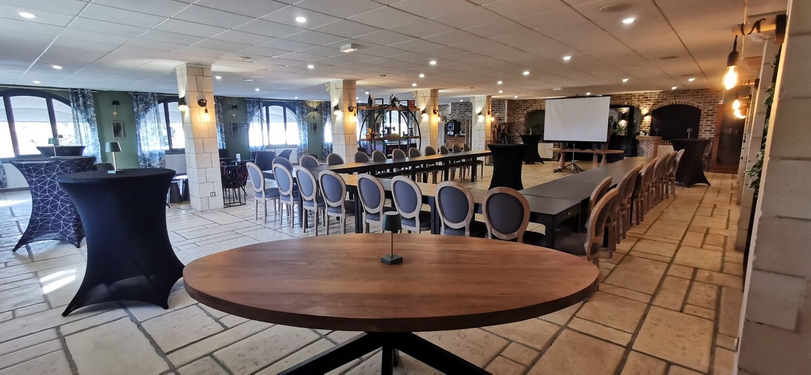 Salle de réunion avec table ronde et écran